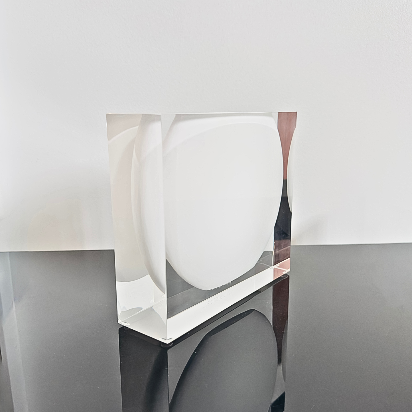 Clear acrylic block on a gray surface with a white background