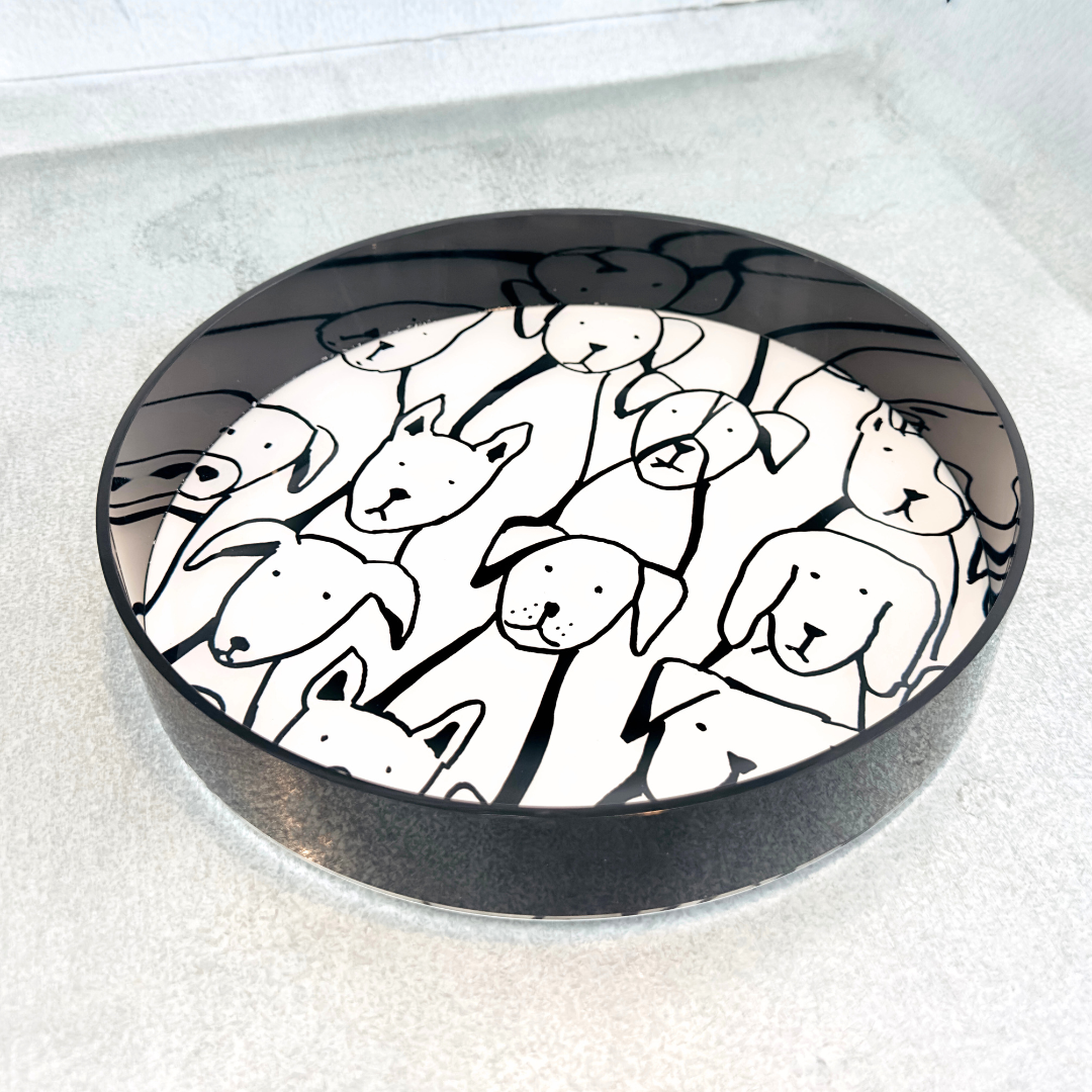 Round black tray with white inside bottom with black dog illustrations on a white surface
