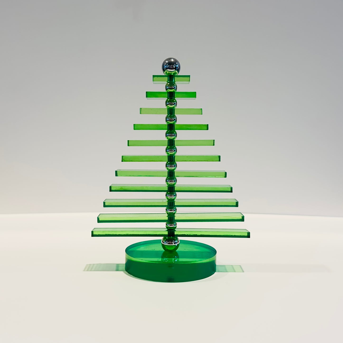 Green acrylic Christmas tree sculpture on a white background