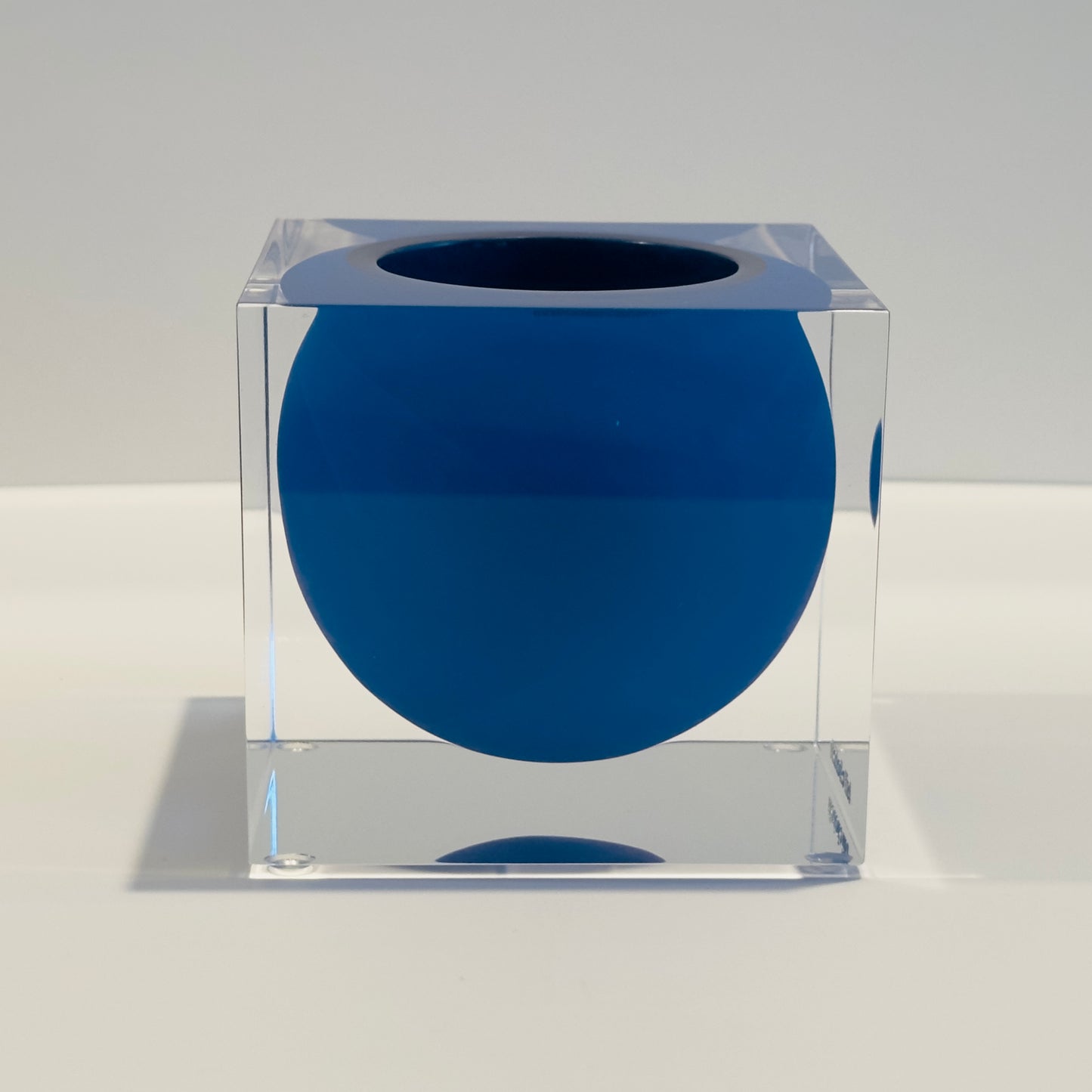 Clear cube with a blue sphere inside on a white background