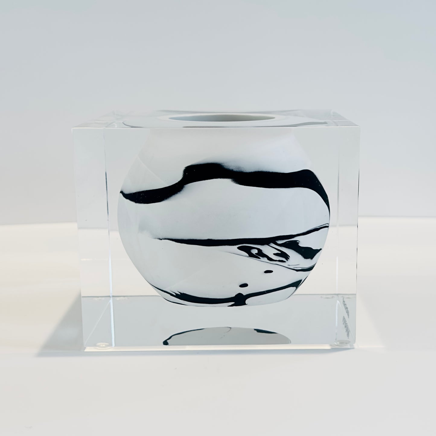 Clear glass block with black and white design on a white background