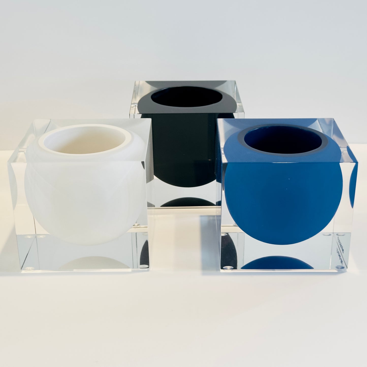 Set of three containers with black, white, and blue interior designs on a white background