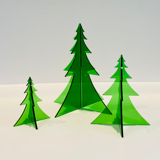Three green Christmas tree-shaped objects on a white surface with a light gray background