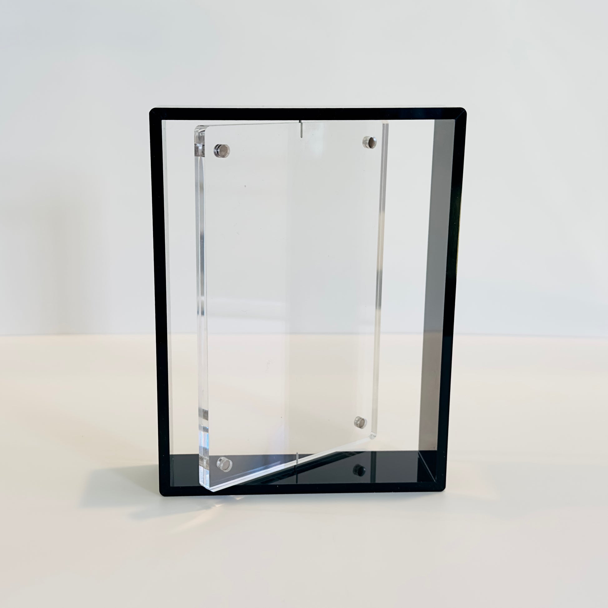 Clear acrylic photo frame with a black frame on a white background