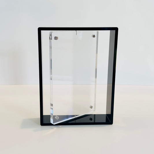 Clear acrylic photo frame with a black frame on a white background