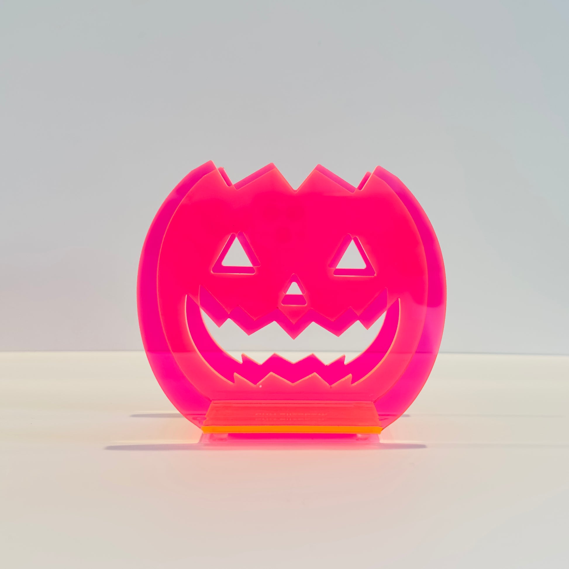 Pink pumpkin-shaped Halloween container on a white background