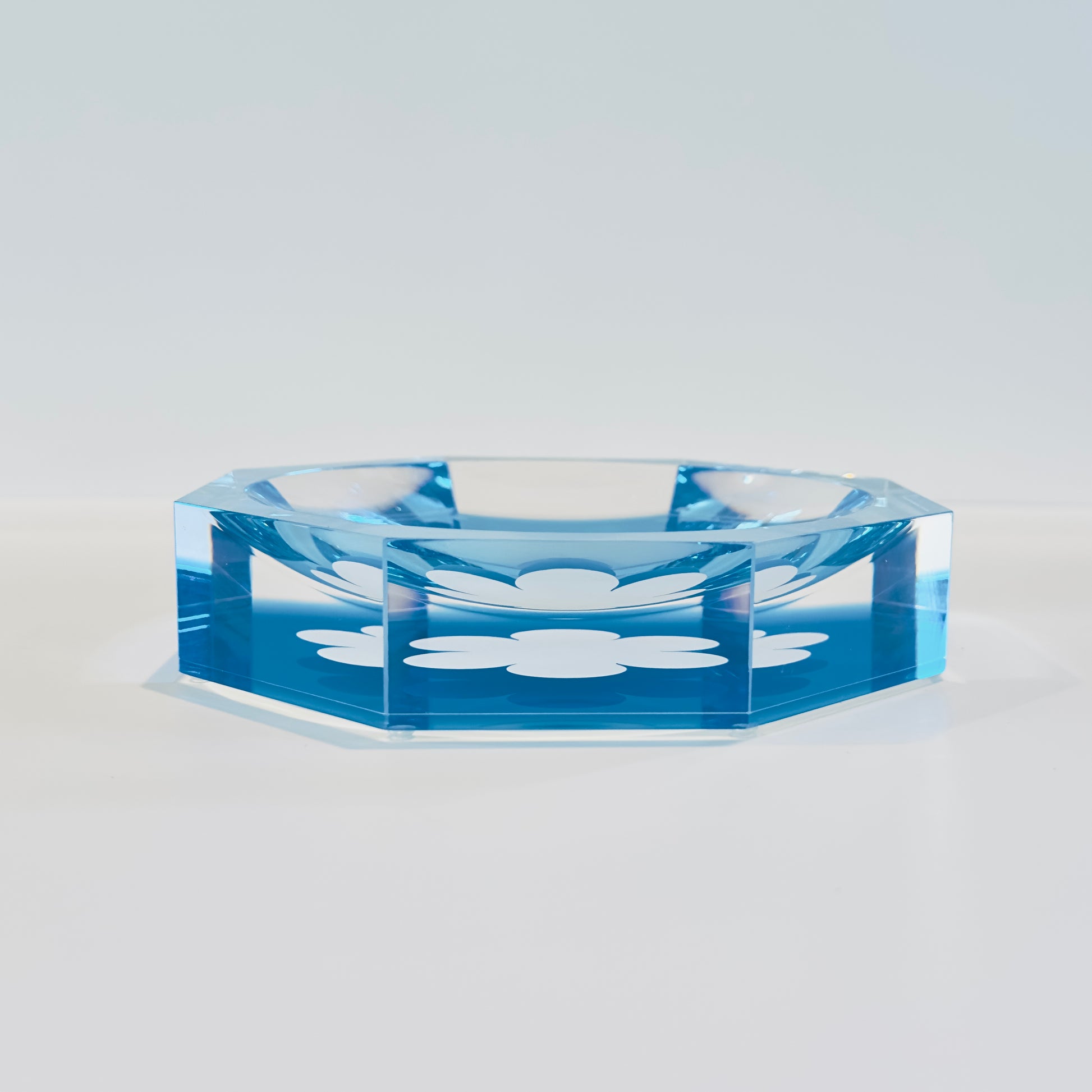 Blue acrylic bowl with floral design on a light gray background