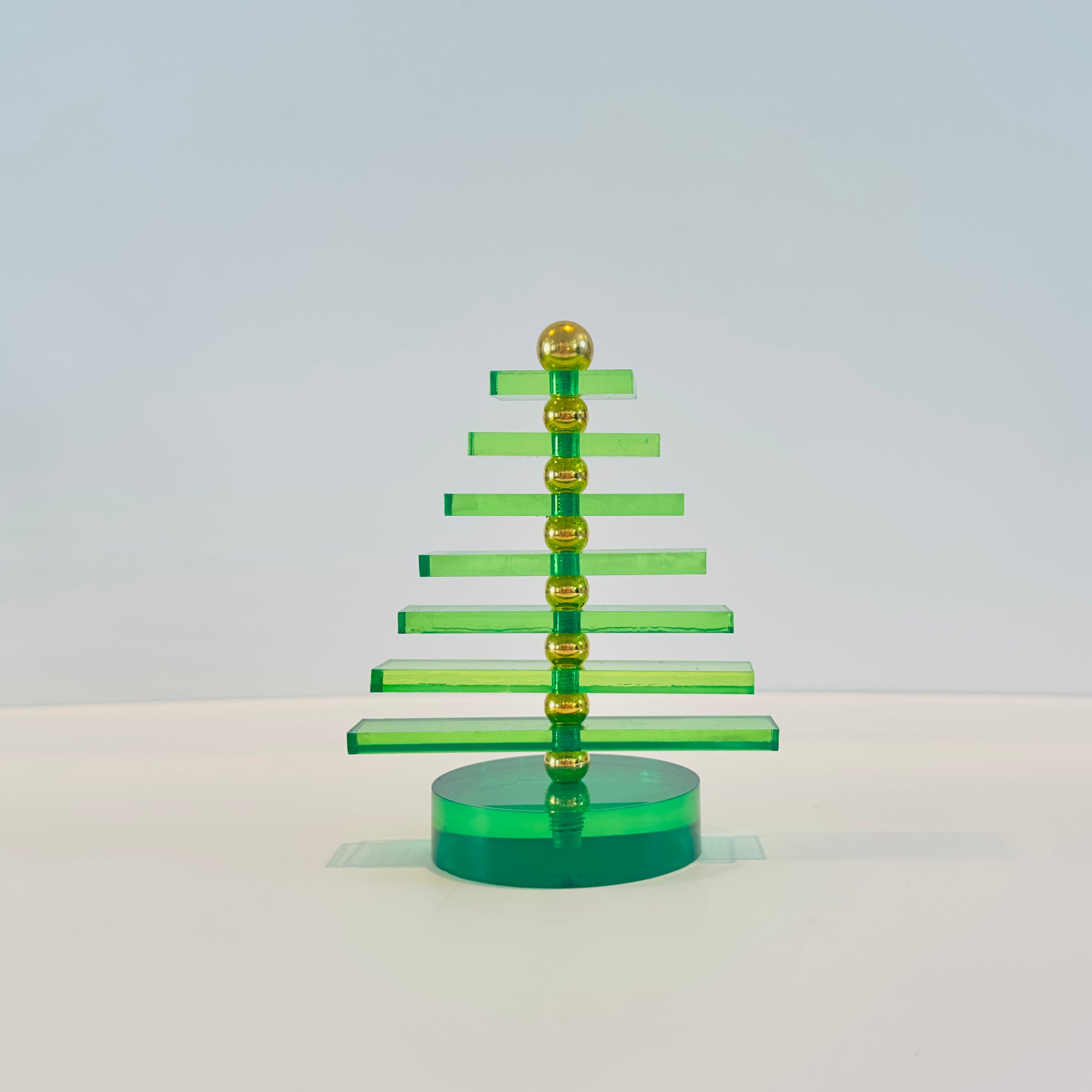 Green and gold Christmas tree decoration on a white background