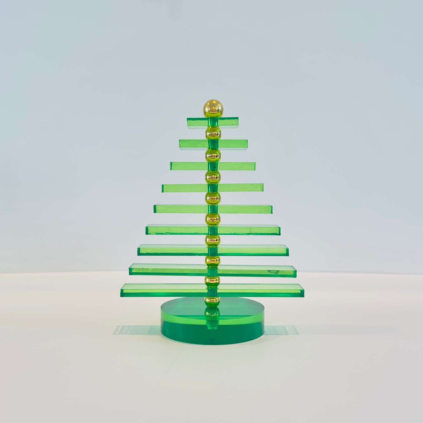 Green and gold Christmas tree decoration on a white background