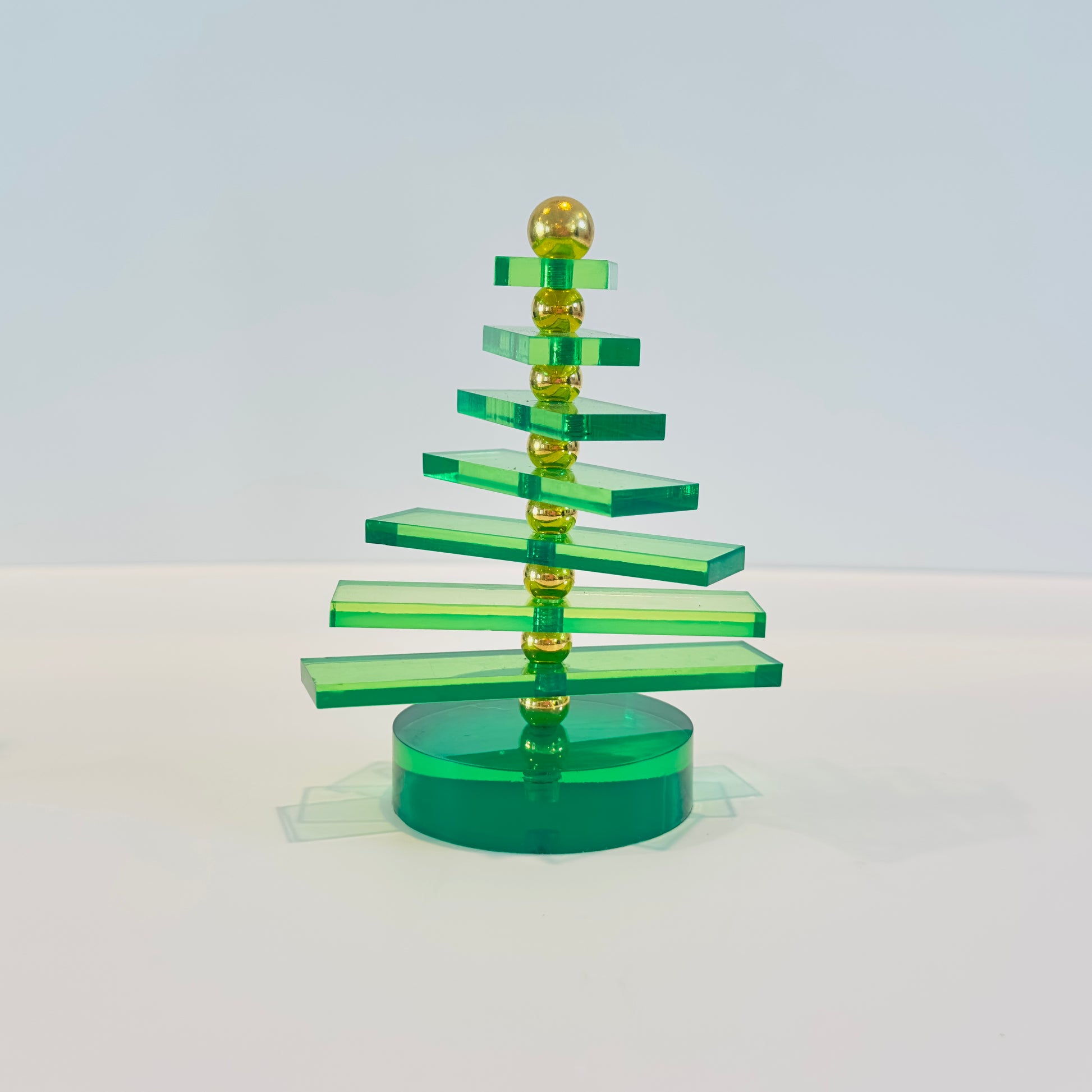 Green and gold Christmas tree ornament on a white background