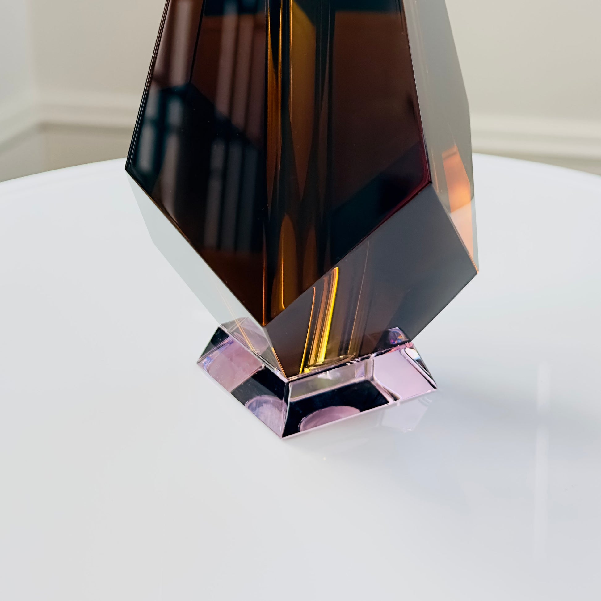 Decorative glass vase with geometric design on a white surface