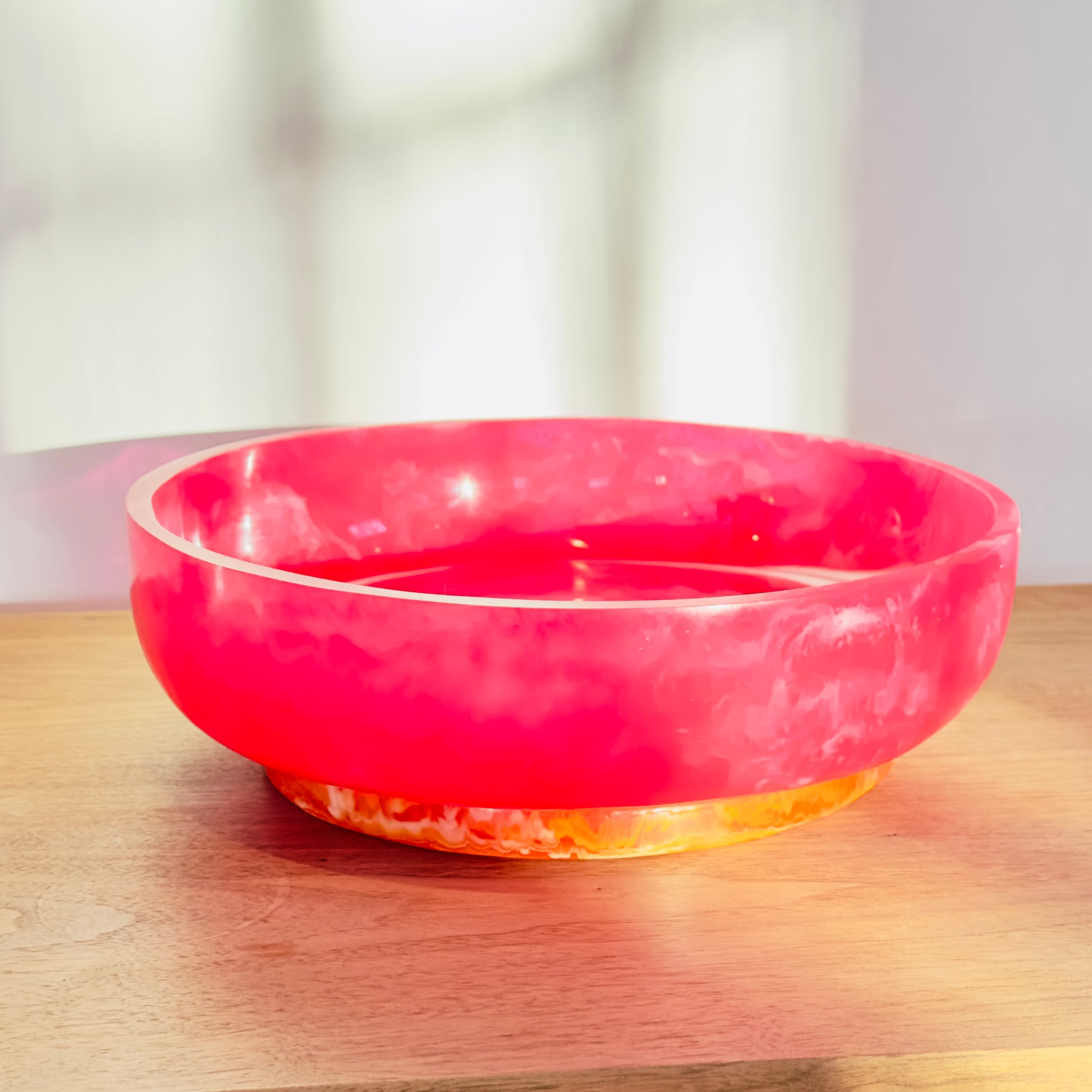Pink bowl on a wooden surface with a blurred background