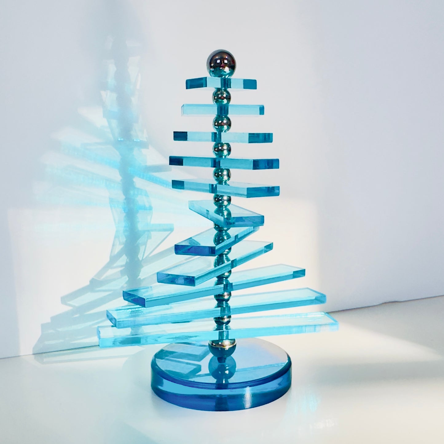 Blue acrylic sculpture on a white background