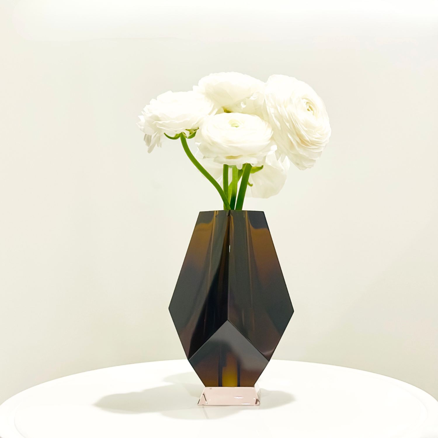 Geometric brown vase with white flowers on a light background