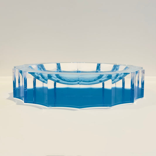 Blue and clear acrylic decorative dish on a light beige background