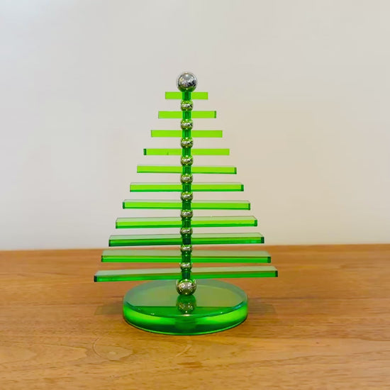 Green Acrylic tree that has moving parts to rotate around the design by hand