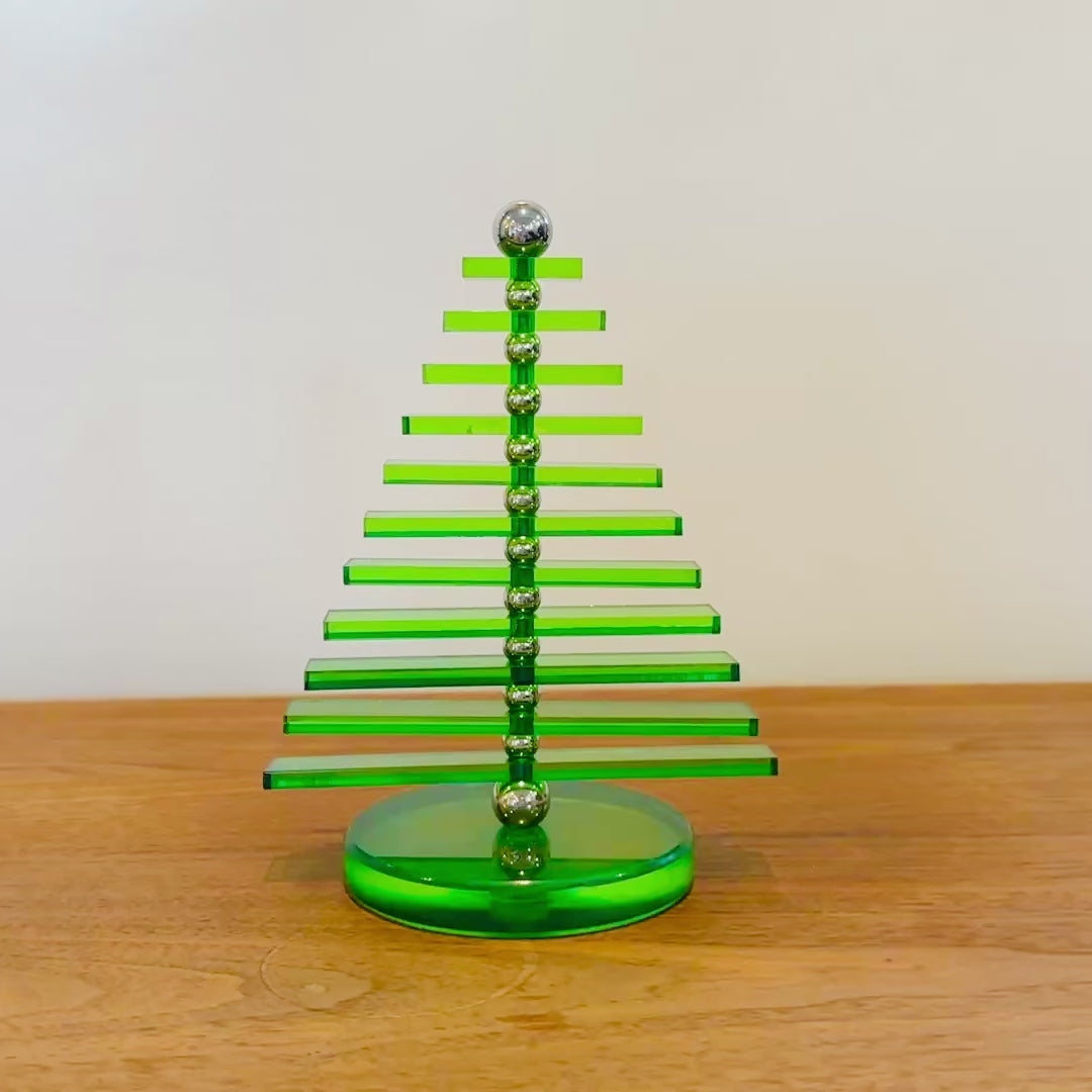 Green Acrylic tree that has moving parts to rotate around the design by hand