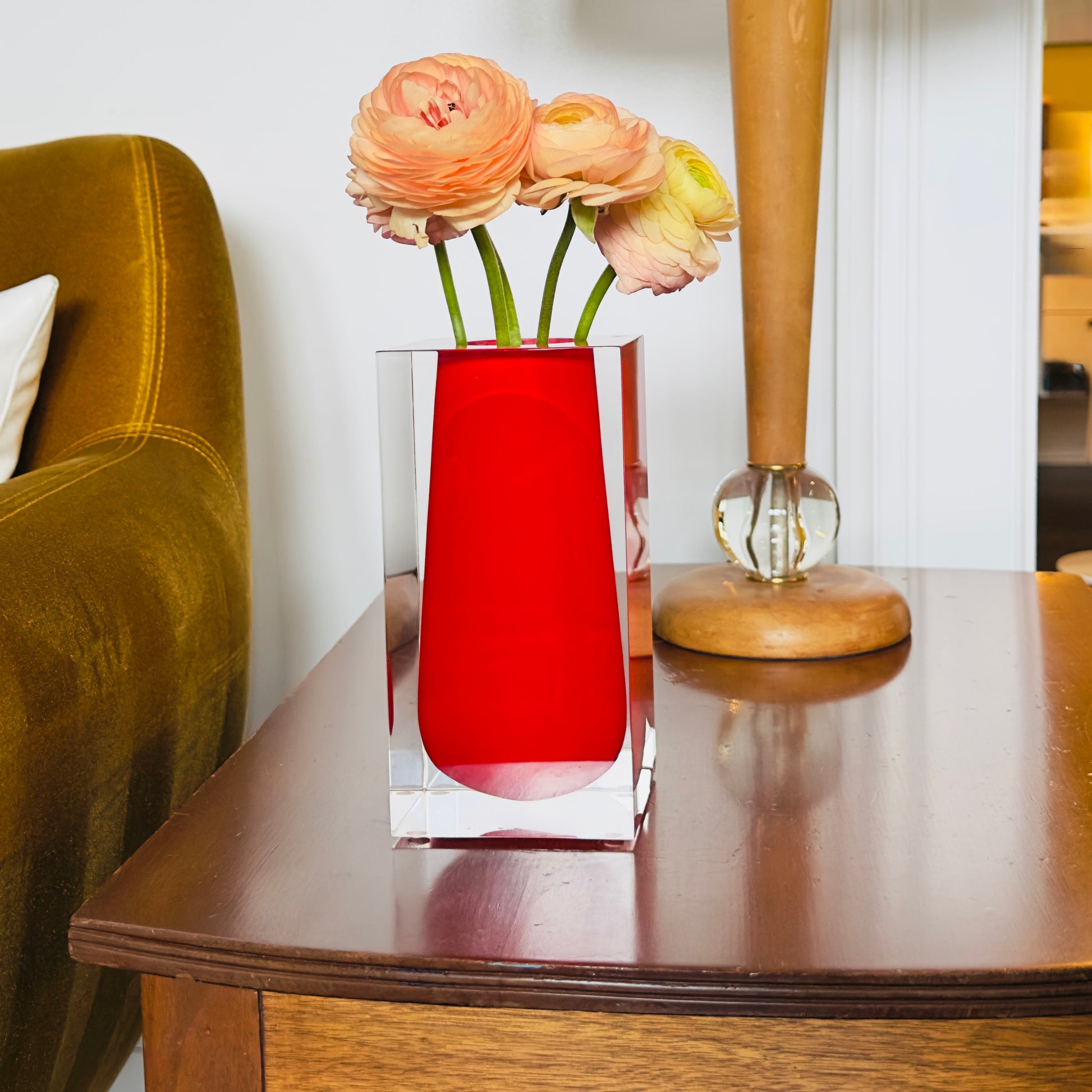 Clear and red vase and flowers on a wooden table